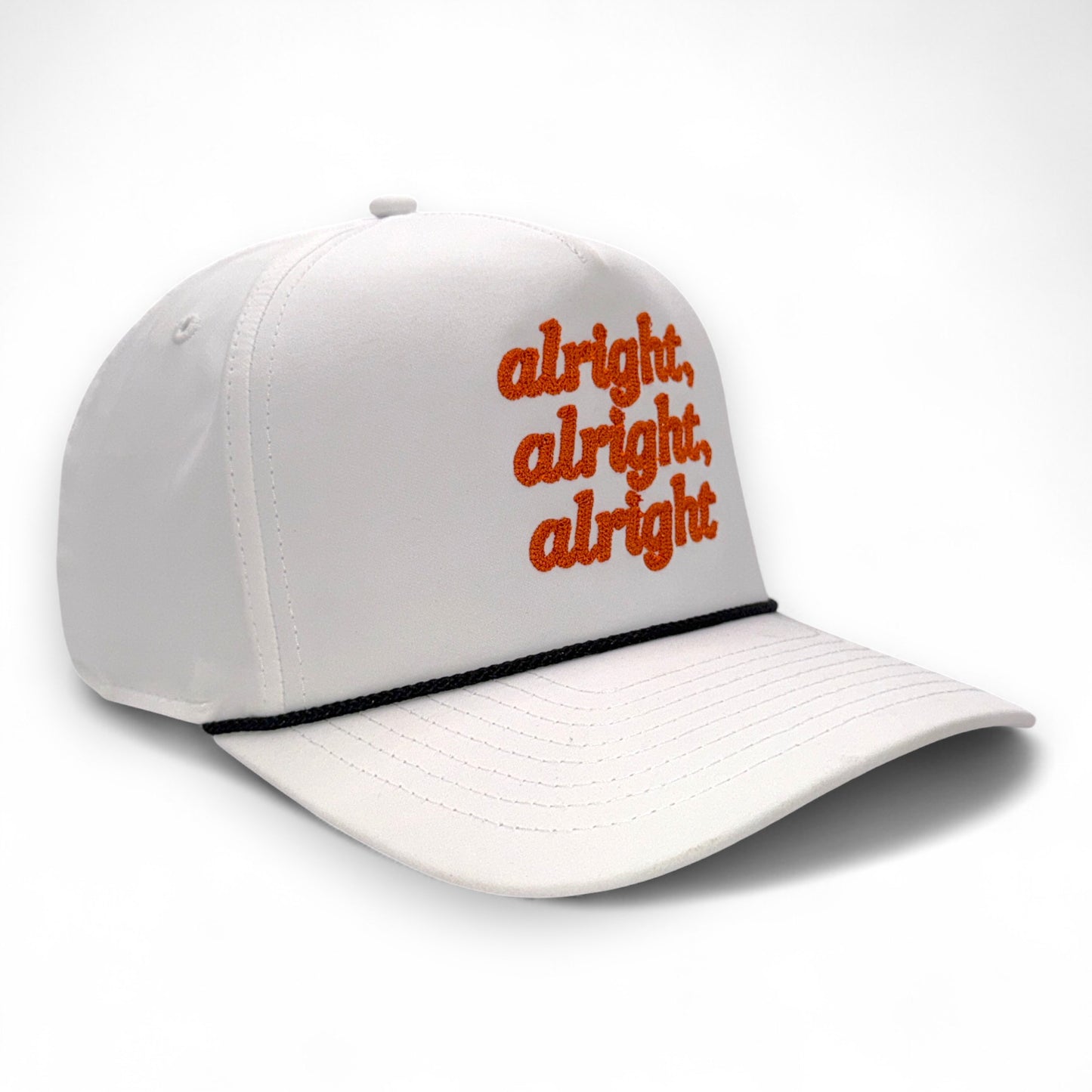 Angled side view of white hat with orange “alright, alright, alright” embroidery and black rope