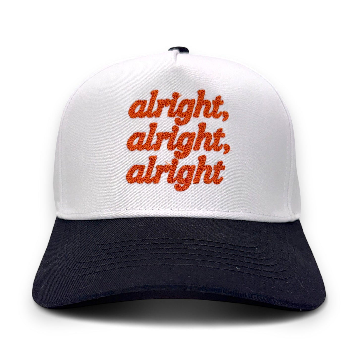 Front view of white and black bill hat with orange “alright, alright, alright” embroidery