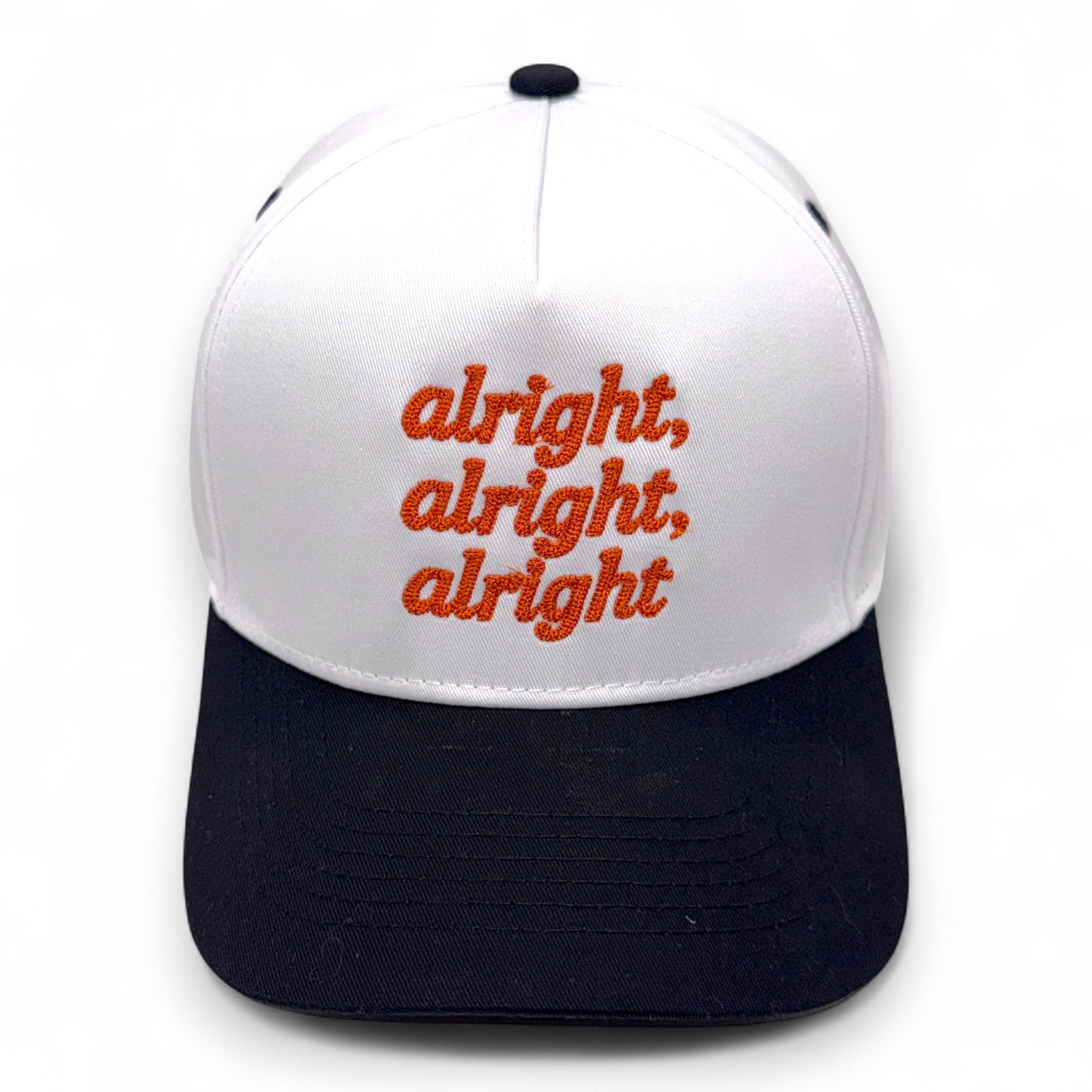 White and black cap with red text 'alright, alright, alright' on a white background