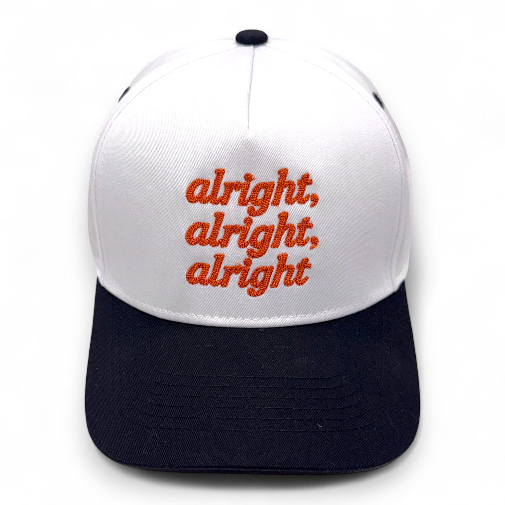 White and black cap with red text 'alright, alright, alright' on a white background