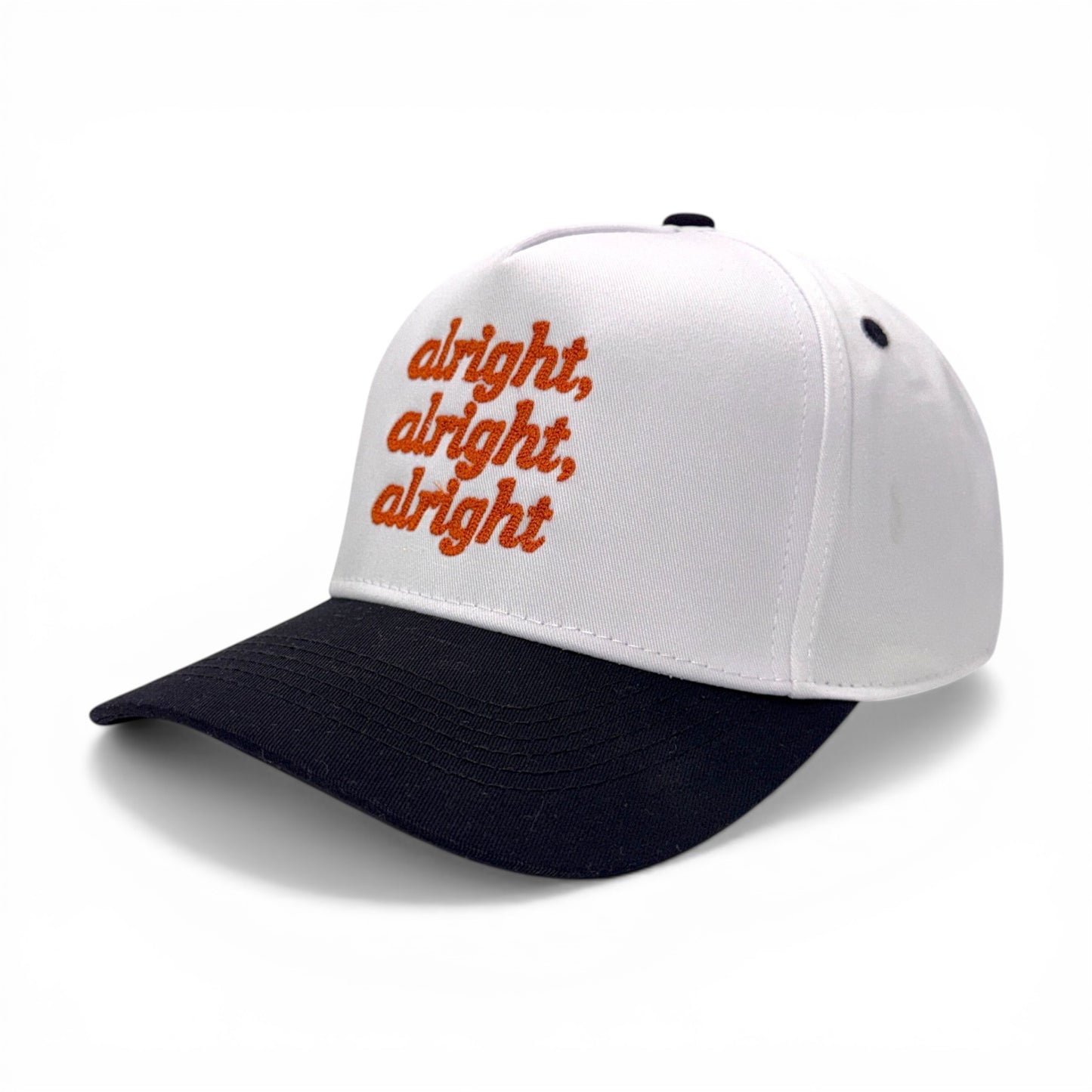 Angled side view of white hat with black bill and orange embroidered text