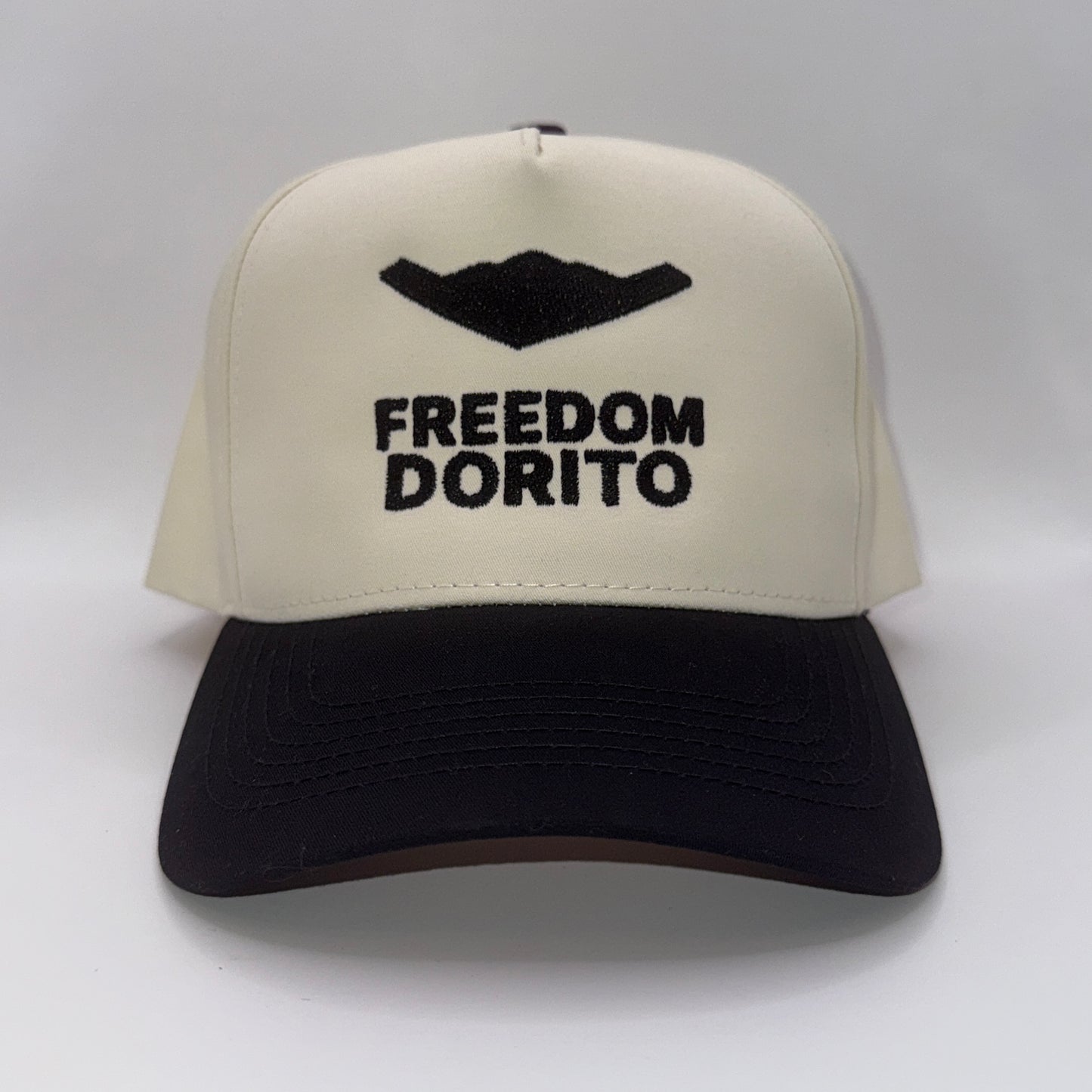 Cream and black snapback hat with embroidered B2 bomber silhouette and text ‘Freedom Dorito’