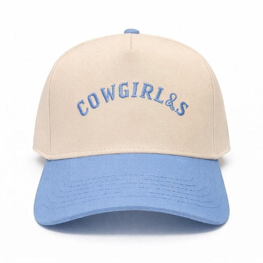 Mad Capper beige baseball cap with blue brim and embroidered "COWGIRLS" lettering.